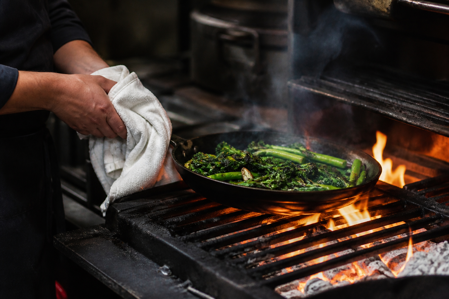 Chef cooking seasonal greens over an open flame